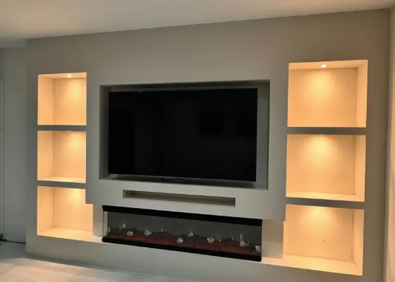 Cinewall met sfeerhaard, soundbarvak en warm verlichte vakken, voorbeeld van cinewallcenter