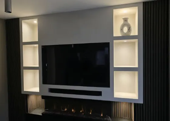 Cinewall met sfeerhaard, soundbarvak, verlichte vakken en wandpanelen, voorbeeld van cinewallcenter