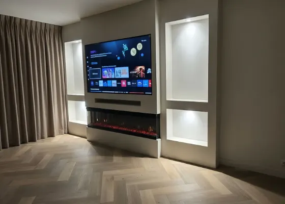 Cinewall met sfeerhaard, soundbarvak en verlichte vakken, voorbeeld van cinewallcenter