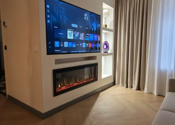 Cinewall met sfeerhaard, soundbarvak en verlichte vakken, voorbeeld van cinewallcenter